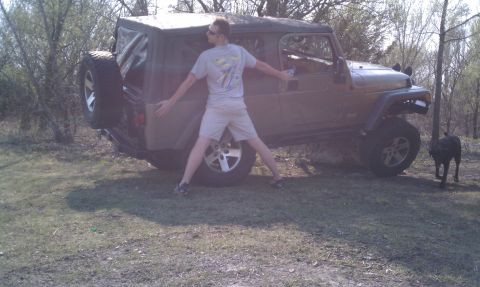 2005 Jeep Wrangler - A person stands with arms outstretched next to a Jeep Wrangler in a grassy, wooded area.