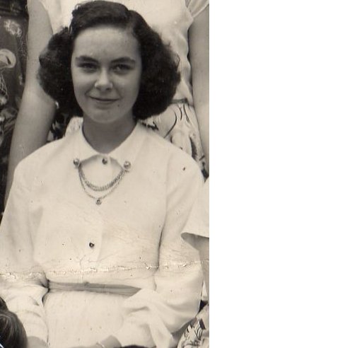Young woman with dark curly hair, wearing a white collared shirt with a decorative chain necklace