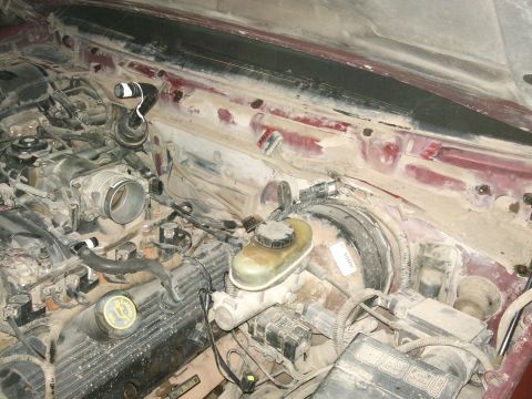 1998 Ford Crown Victoria - The engine bay is covered in dust and grime, obscuring many details.