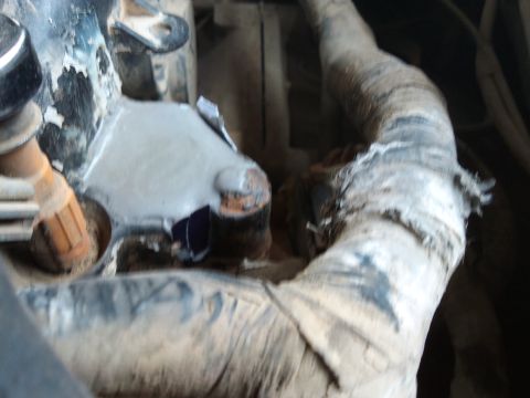 1998 Ford Crown Victoria - Engine bay detail showing hoses and metal parts, some appear worn or damaged.