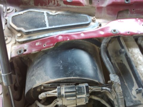 1998 Ford Crown Victoria - This photo shows the area around the vehicle's wiper tray, including electrical connectors and a black plastic housing.