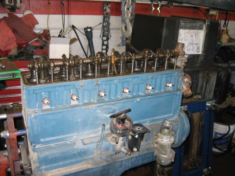 1998 Ford Crown Victoria - long blue inline engine block sits on a rolling cart in a garage, with a handwritten KEEP OUT sign behind it.