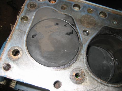 1998 Ford Crown Victoria - Engine block deck surface showing two adjacent cylinder bores, threaded bolt holes and light corrosion.