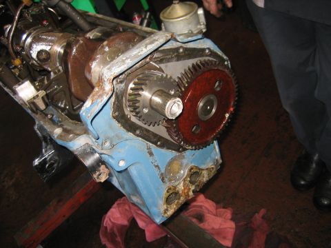 1998 Ford Crown Victoria - Front of a blue engine block showing the camshaft timing gear, red crank gear and crankshaft snout during assembly.