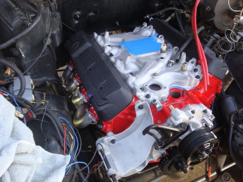 1989 Ford Bronco - Engine bay view of a V8 engine during installation or repair, showing intake and exhaust components.