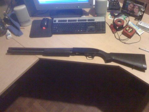 1991 Nissan Pathfinder - A shotgun is displayed on a desk next to a computer keyboard and mouse.