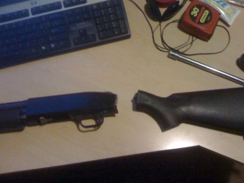 1991 Nissan Pathfinder - The receiver and stock of a shotgun are disassembled on a wooden surface, with various tools and a keyboard nearby.