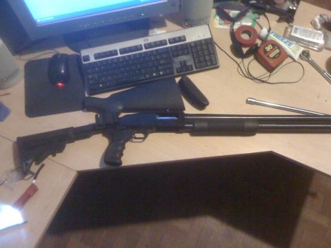 1991 Nissan Pathfinder - A shotgun with a tactical stock and scope is displayed on a desk next to a computer keyboard and mouse.