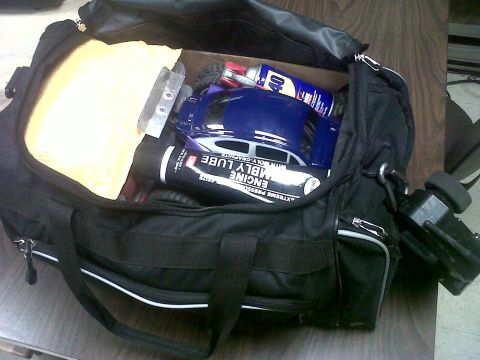 2011 Ford 427 - A duffel bag contains a blue remote control car body, lubricants, and a remote control.