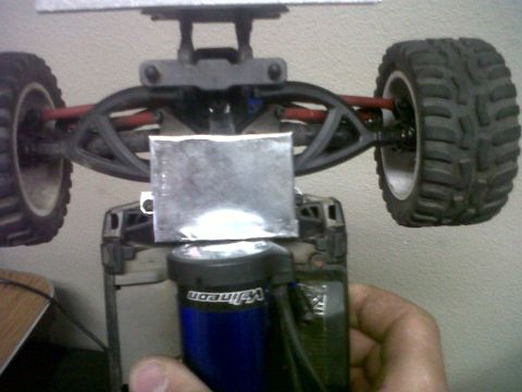 2011 Ford 427 - Close-up of an RC car's suspension and motor, with a metal plate affixed.