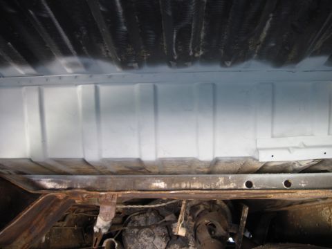 1979 Ford Bronco - The underside of a vehicle reveals its frame, suspension, and drivetrain components, showing signs of both wear and recent maintenance.