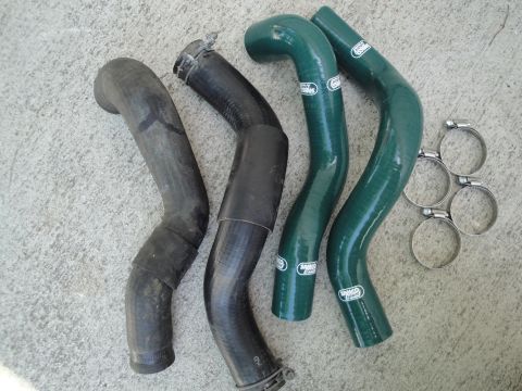 1995 Ford Taurus - Four radiator hoses, two black rubber and two green silicone, are laid out with four hose clamps.