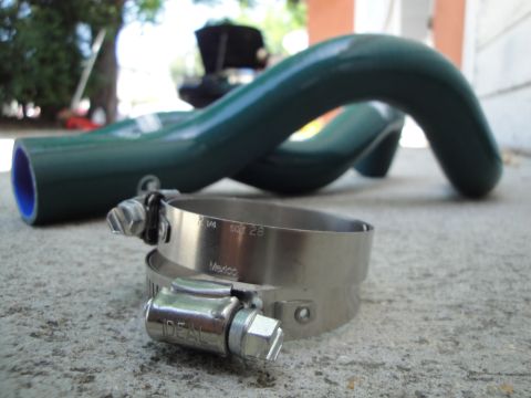 1995 Ford Taurus - A green silicone hose and an IDEAL brand hose clamp are shown resting on a concrete surface.