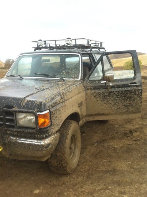 1990 Ford Bronco - This truck appears to be a Ford F-Series, not a Bronco, covered in mud after off-roading.