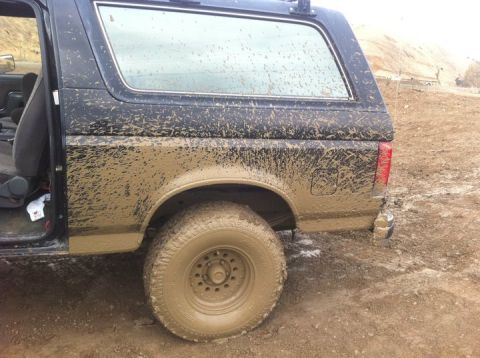 1990 Ford Bronco - This 1990 Ford Bronco is heavily covered in mud, suggesting it has been used off-road.