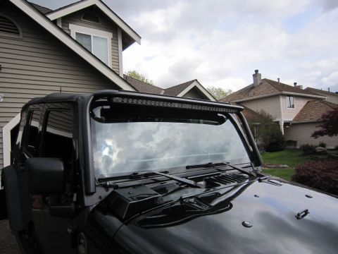 2008 Jeep Wrangler - A black Jeep Wrangler is parked in front of a house, equipped with a lightbar above the windshield.
