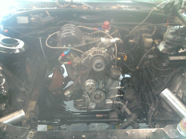 Engine bay with engine and some components visible. Some wiring and hoses are connected