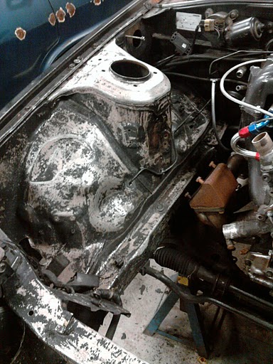 1987 Mazda RX-7 - The engine bay of a car is shown, with some components removed and the firewall exposed.