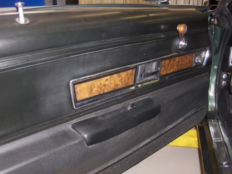 1970 Chevrolet Camaro - The interior door panel of a 1970 Chevrolet Camaro features wood grain accents and a black armrest.