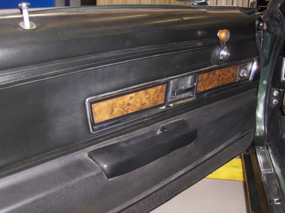 1970 Chevrolet Camaro interior door panel with wood grain trim and black armrest