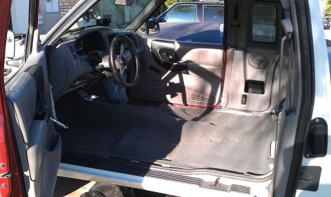 1992 Ford Ranger - Interior view of a 1992 Ford Ranger pickup truck, with a second vehicle behind it.
