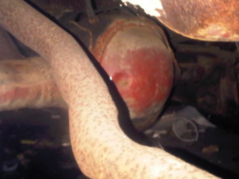 1973 Ford Ranchero - Underside view of a vehicle's exhaust system and differential, showing signs of rust and wear.