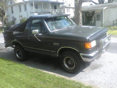 1988 Ford Bronco - This 1988 Ford Bronco features a dark green exterior and a soft top configuration.