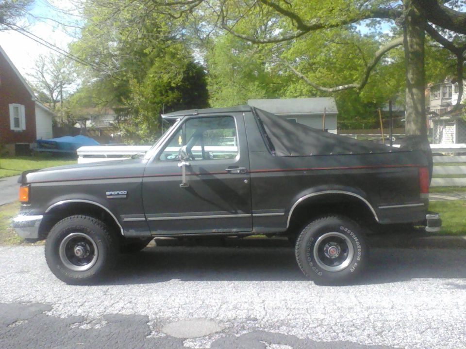 1988 Ford Bronco with soft top parked on a street
