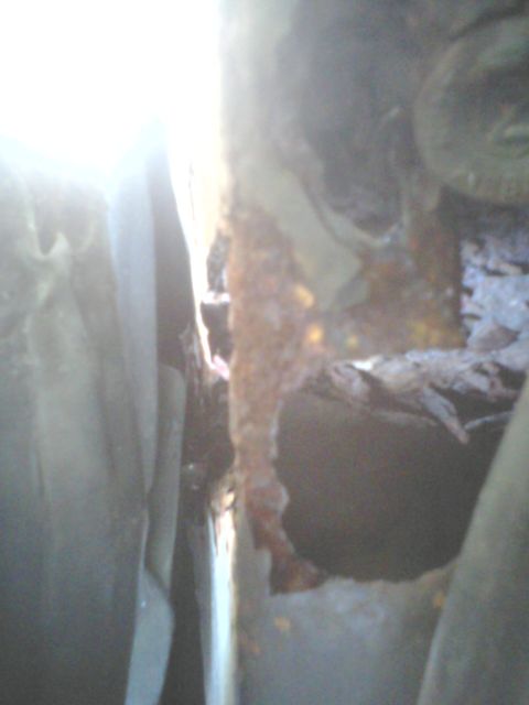 1988 Ford Bronco - Detail of significant rust and damage to the interior structure of a vehicle, obscuring specific identification.
