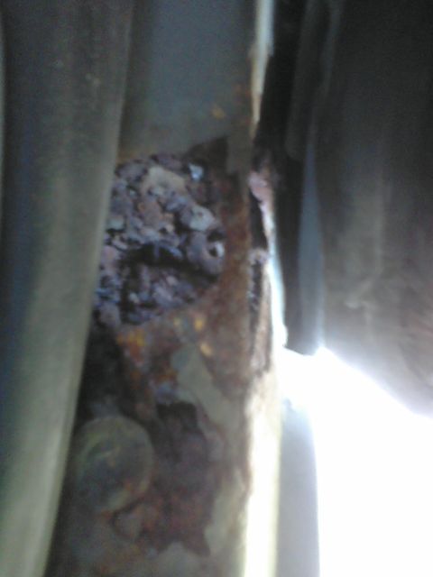 1988 Ford Bronco - Close-up of a heavily rusted vehicle frame rail, showing significant corrosion.