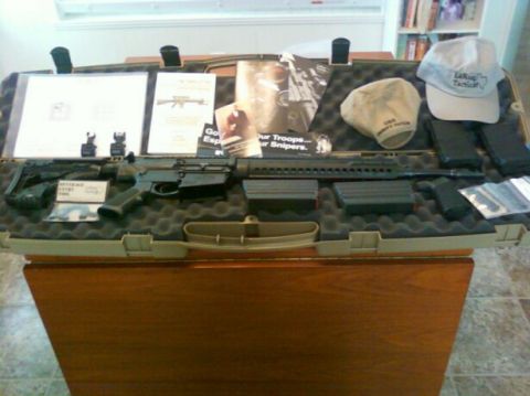 1996 Ford Bronco - A rifle, extra magazines, and various documents are displayed within a protective case, alongside two hats.