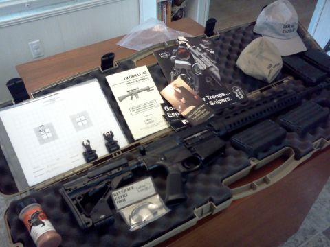 1996 Ford Bronco - A rifle and its accessories are laid out in a case on a wooden table.