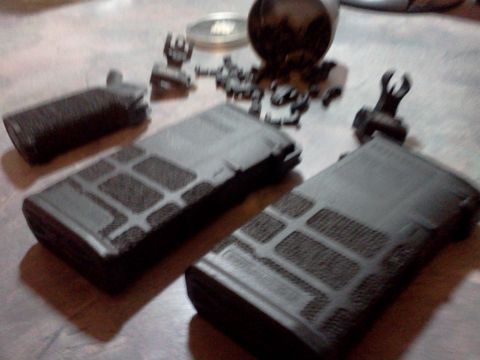 1996 Ford Bronco - Several firearm magazines and components are laid out on a textured surface.