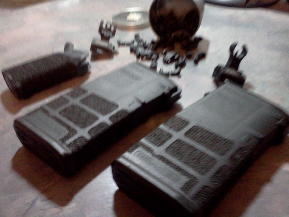 Two gun magazines and various firearm parts on a table