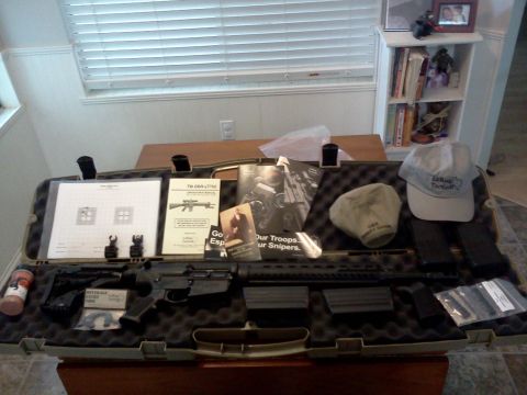 1996 Ford Bronco - A rifle case contains a rifle, magazines, and various documents, including a target sheet and instruction manuals.