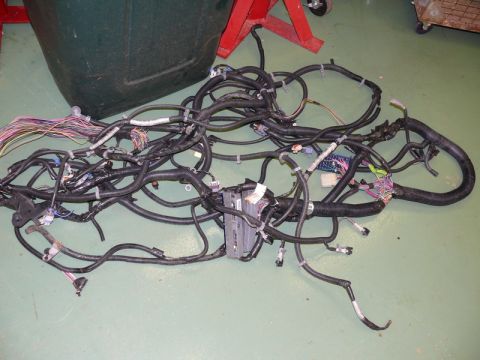 1976 Chevrolet Corvette - A complex automotive wiring harness lies on the floor, disconnected from any vehicle.