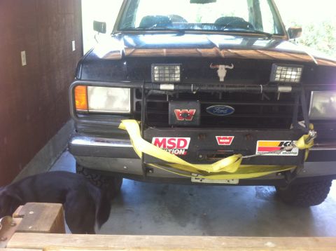 1990 Ford Bronco - This Ford truck features a bull skull emblem and various aftermarket accessories on its front bumper and grille.