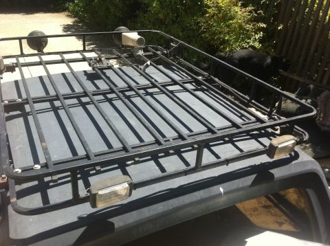 1990 Ford Bronco - A close-up view of a vehicle's roof rack, equipped with auxiliary lights and a spotlight.
