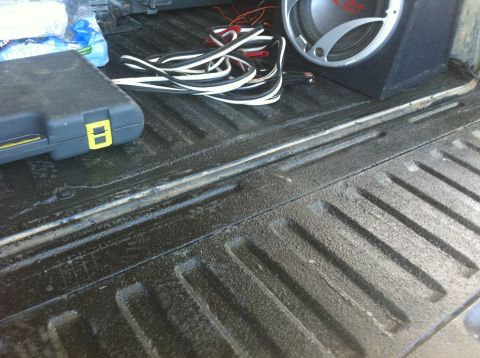 1990 Ford Bronco - Contents of a truck bed, including a toolbox and audio speaker, with a Supermotors.net watermark.