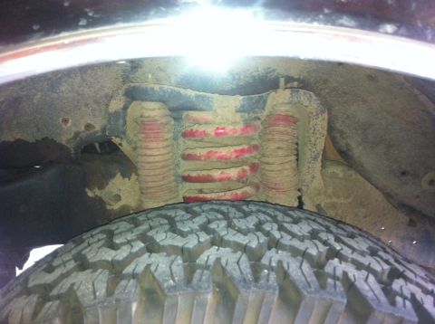 1990 Ford Bronco - Close-up of front suspension components, including coil springs and shock absorber.