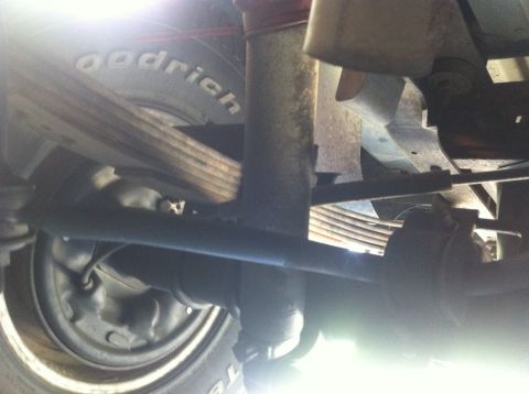 1990 Ford Bronco - Close-up of vehicle undercarriage components, including suspension and tire.