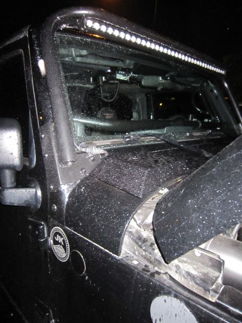 2008 Jeep Wrangler - Night shot of the driver's side cowl and windshield frame on a rain-beaded black Jeep Wrangler with an LED light bar mounted on the windshi…