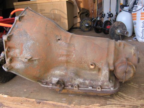 1980 Jeep CJ7 - This heavily rusted automatic transmission is shown resting on a wooden surface, with a SuperMotors logo visible at the bottom right.