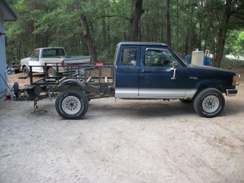 1994 Ford Explorer - Side view of a 1994 Ford Ranger pickup truck chassis with a custom bed frame. Another truck is visible in the background.