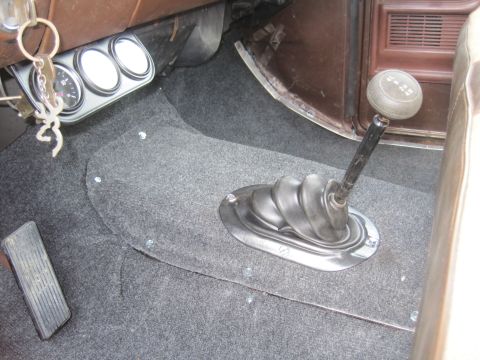 1979 Ford Bronco - The interior of the vehicle features a manual transmission shifter and a set of auxiliary gauges.