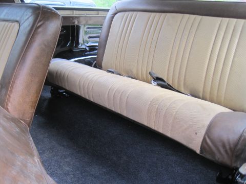 1979 Ford Bronco - The interior features tan fabric seats with brown vinyl trim and dark carpeting.