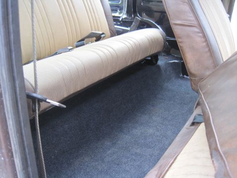 1979 Ford Bronco - Interior view showing tan and brown seats with dark carpeting on the floor.