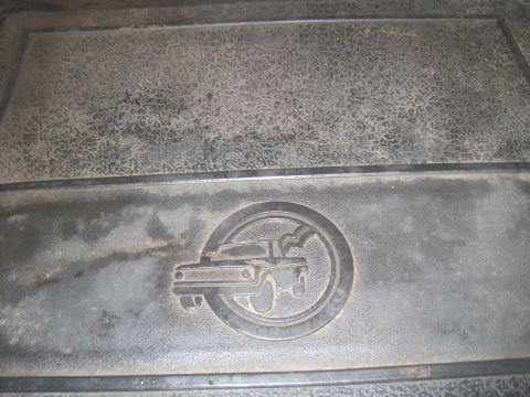 1979 Ford Bronco - A close-up shows a circular emblem with a truck design embossed on a textured surface, likely a floor mat.