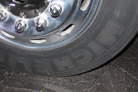 2003 Ford F-350 - A close-up shot focuses on the chrome wheel and tire of a large truck, showing the Michelin brand and tire size information.