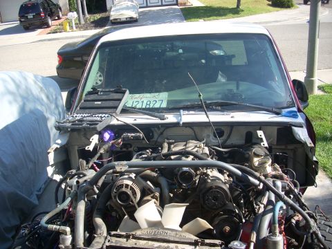 1992 Ford Ranger - The engine bay of a truck is exposed, with various components and wiring visible. A California license plate is on the dashboard.